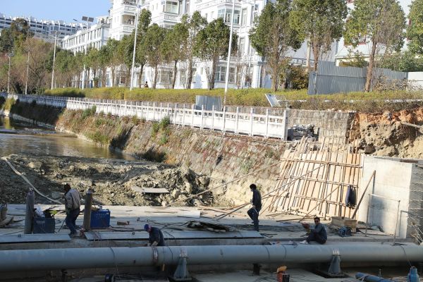 图为工人正在建设河道钢坝的剪影